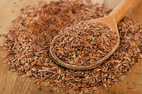 Montón de semillas de lino en cuchara de madera . — Foto de Stock