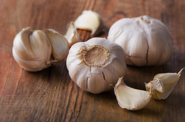 Organische knoflook op een oude houten achtergrond. — Stockfoto