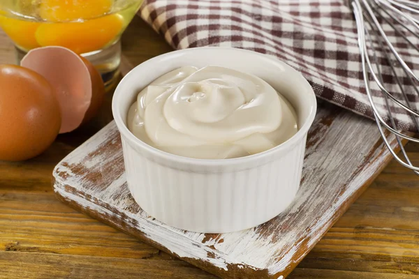 Mayonnaise in einer Schüssel auf hölzernem Hintergrund — Stockfoto