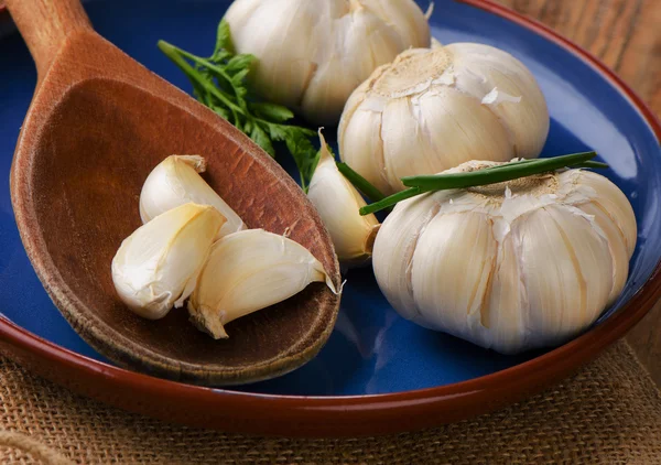 Roher Bio-Knoblauch auf einem Tonteller. — Stockfoto