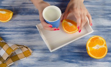 Woman hands holding a cup of milk .