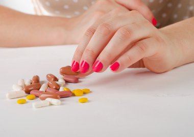 Bir hap tutan genç kadın el.