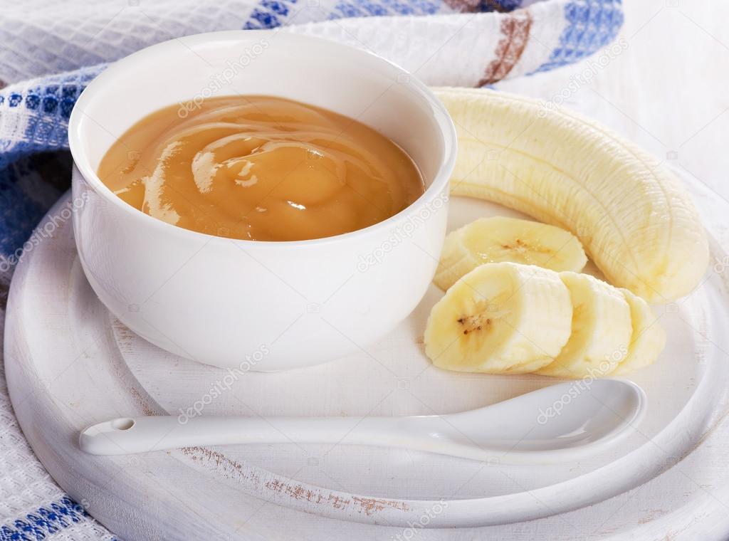Baby food - bananas puree in a white bowl. 