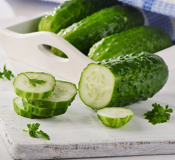 Cetriolo affettato fresco su tagliere bianco . — Foto Stock