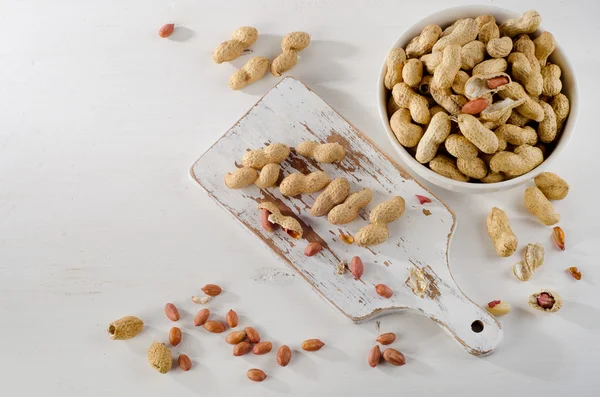 Amendoim em conchas no fundo branco . — Fotografia de Stock