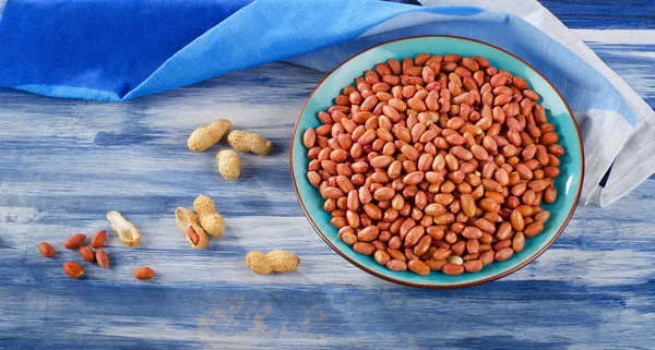 Peanuts on  a  blue table . — Stock Photo, Image