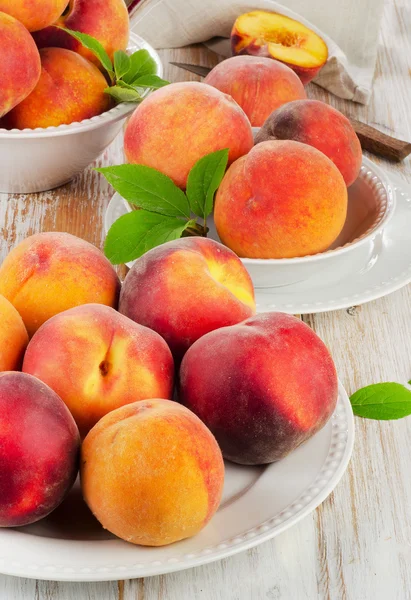 Färska persikor på ett träbord — Stockfoto