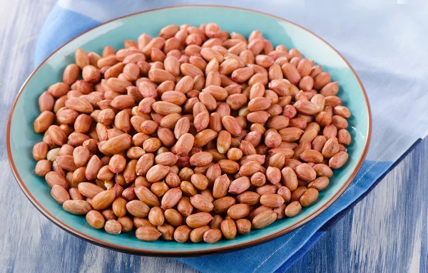 Peanuts on blue plate — Stock Photo, Image