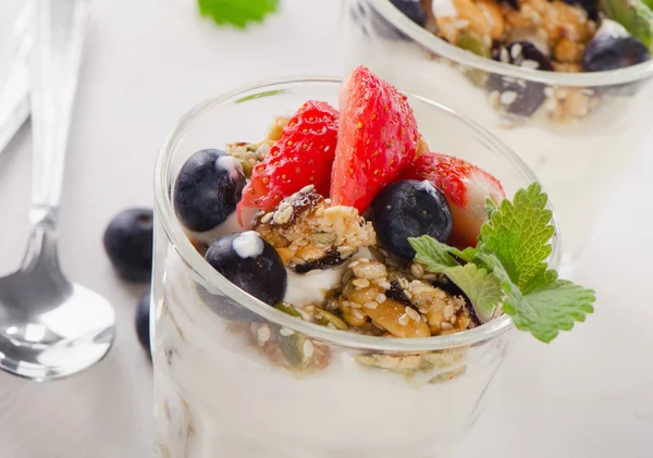 Granola with yogurt and berries in glasses.