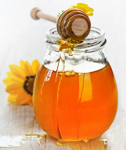 Jar of honey with wooden stick — Stock Photo, Image