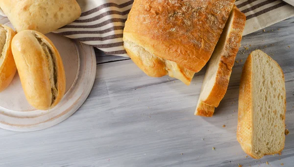Beyaz ahşap kesme tahtası üzerinde ekmek. — Stok fotoğraf