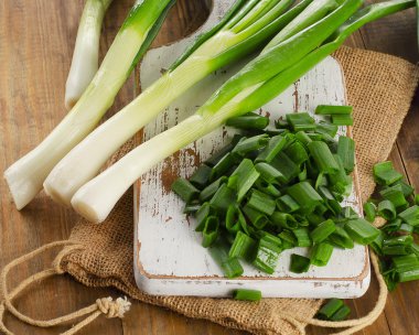 Green onions on a   wooden cutting board. clipart