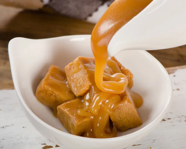 Caramel sauce pouring in bowl. — Stock Photo, Image