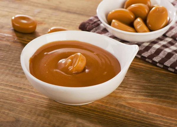 Caramel candies and sauce — Stock Photo, Image