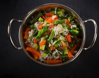 Rice with vegetables on a black background