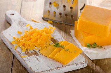 Grated Cheddar Cheese on  a wooden Board