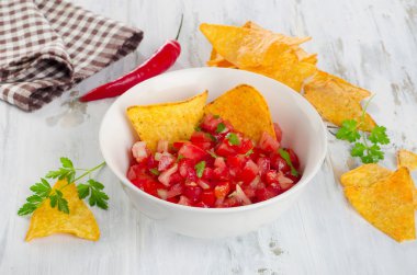 Bowl of  homemade salsa dip with chips clipart