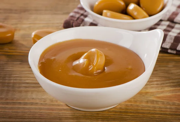 Caramel candies and sauce — Stock Photo, Image