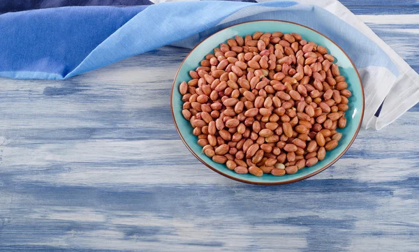 Peanuts on blue plate — Stock Photo, Image