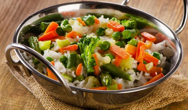 Rice with vegetables on wooden table. — Stock Photo, Image