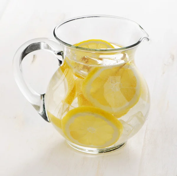 Вода з лимоном у скляному глечику — стокове фото