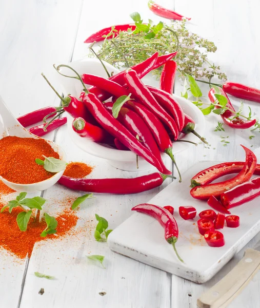 Piros chili paprika, friss fűszernövények, fehér tálban. — Stock Fotó
