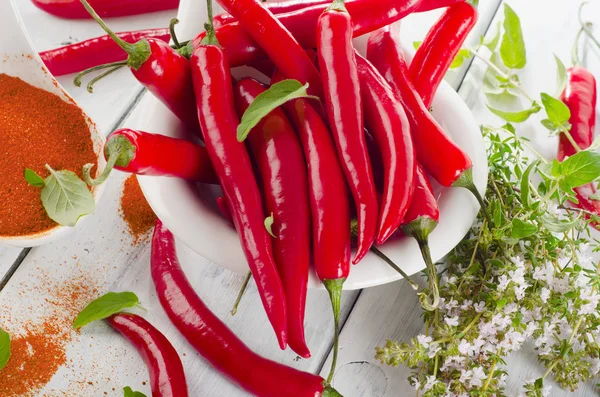 Red chili peppers with herbs leaves — Stock Photo, Image