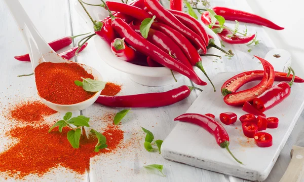 Piros chili paprika, fehér tálban gyógynövényekkel. — Stock Fotó