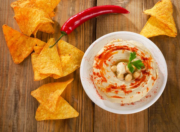 Hummus with nachos on  wooden table. — Stock Photo, Image