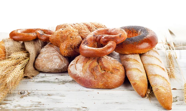 Pão assado fresco em uma mesa de madeira — Fotografia de Stock