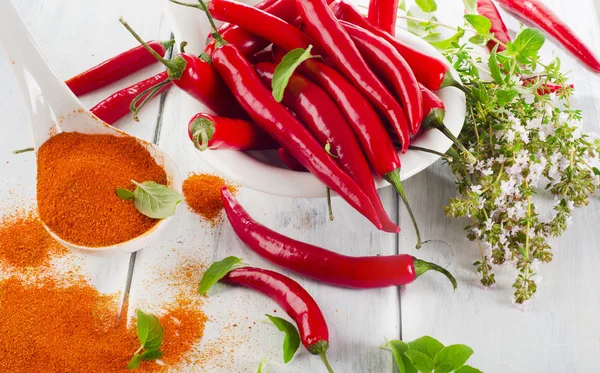 Red chilli peppers with fresh herbs — Stock Photo, Image