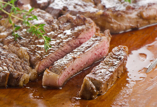 Beef steaks on a wooden table. Selective focus