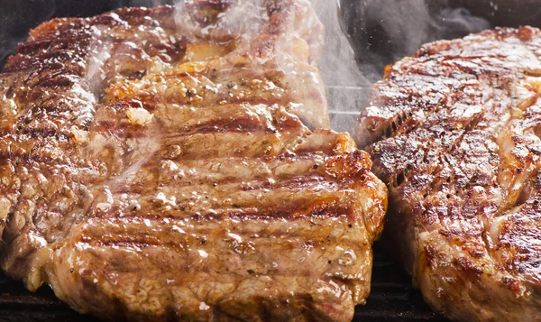 Bife de vaca em uma panela de grelha — Fotografia de Stock