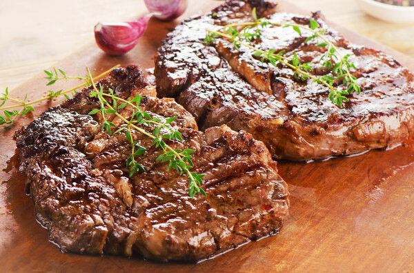 Beef steaks on wooden table. Selective focus