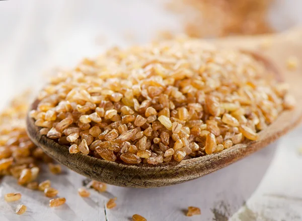 Bulgur en cuchara de madera — Foto de Stock