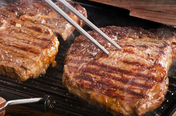 Bifes de carne em uma panela de grelha . — Fotografia de Stock