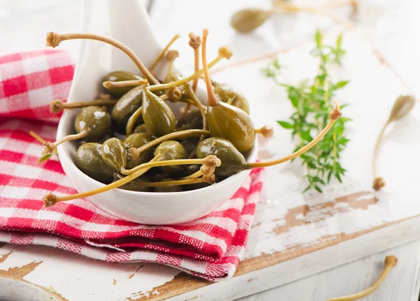 Alcaparras en una cuchara con hierbas . — Foto de Stock