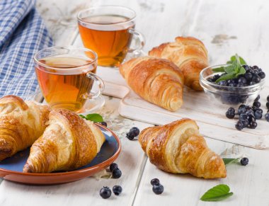 Çay bardağı ile taze kruvasanlar