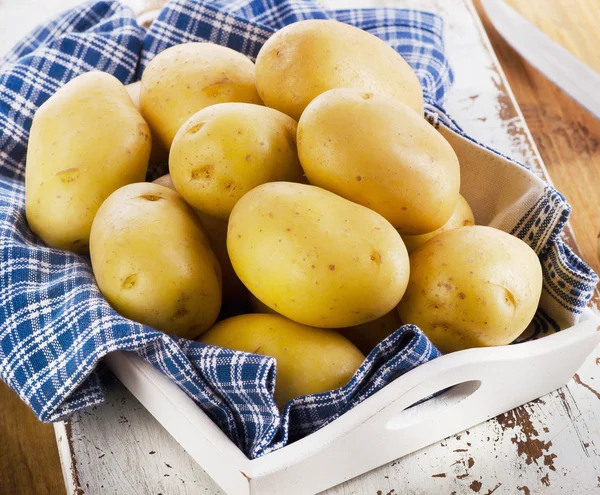 Verse aardappelen op houten ondergrond. — Stockfoto