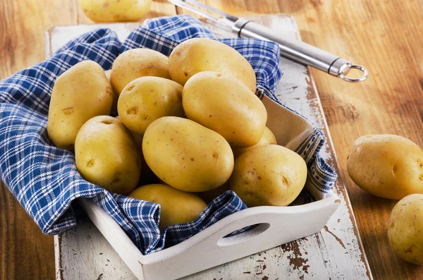 Batatas cruas frescas em fundo de madeira. — Fotografia de Stock