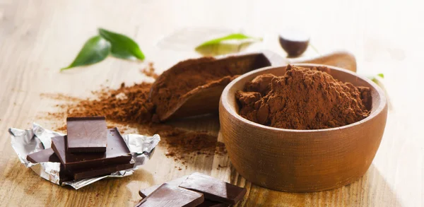 Chocolate bars and bowl of cacao powder. — Stock Photo, Image