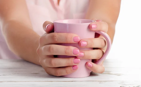 Woman's hands holding pink cup. — Stock Photo, Image