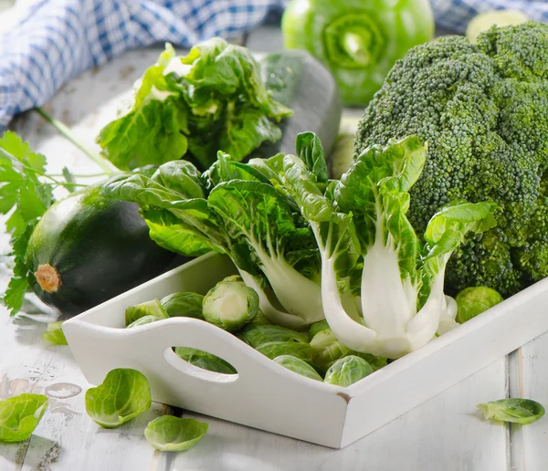 Verdure verdi su tavolo di legno bianco . — Foto Stock