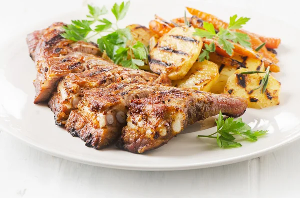 Costillas de cerdo a la parrilla en plato blanco . — Foto de Stock