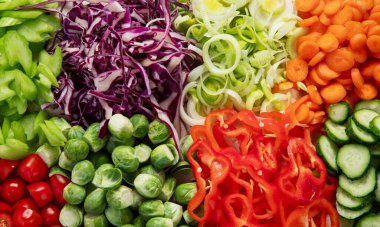 Dilimlenmiş ve rengarenk taze sebzeler hafif bir arka planda yemek hazırlama. Üst görünüm. 