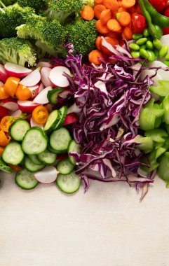 Çeşitli taze sebzeler: havuç, salatalık, kırmızı dolma biber, domates, salata, hafif arkaplanda soğan. Üst Manzara. Boşluğu kopyala.