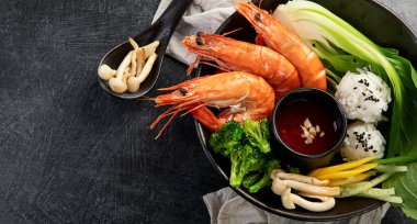 Koyu arkaplanda pirinç ve sebzeli karides. Tayland yemeği. Asya yemekleri. Üst görünüm.