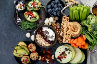 Çeşitli humus sosları. Sebzeli humus tabağı. Havuç, kereviz çubukları. Vejetaryen ve geleneksel humus karanlık bir arka planda sağlıklı ve vejetaryen atıştırmalığı gibidir. Üst görünüm.