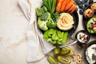 Çeşitli humus sosları. Sebzeli humus tabağı. Havuç, kereviz çubukları. Vejetaryen ve geleneksel humus hafif bir arka planda sağlıklı ve vejetaryen atıştırmalığı gibidir. Üst görünüm.