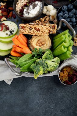 Çeşitli humus sosları. Sebzeli humus tabağı. Havuç, kereviz çubukları. Vejetaryen ve geleneksel humus karanlık bir arka planda sağlıklı ve vejetaryen atıştırmalığı gibidir. Üst görünüm.